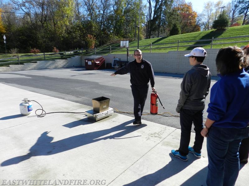 Career Firefighter Matt Cole explaining the use of a fire extinguisher to residents during a fire safety event at Station 5.